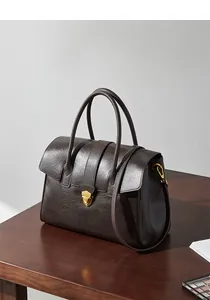 Dettaglio della borsa in pelle testa di moro con trama fine e chiusura a scudo dorata