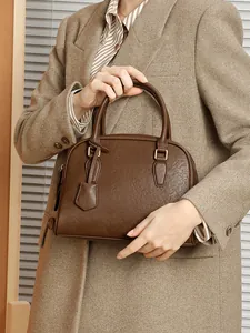 Borsa Boston in pelle testa di moro con doppi manici indossata da una modella elegante