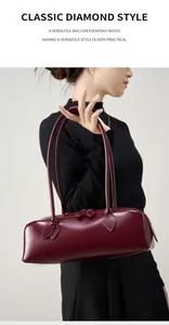 Dettaglio della borsa baguette in pelle bordeaux con doppi manici e finitura opaca