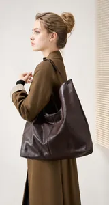 Vista lateral de un gran bolso tote de cuero marrón oscuro llevado por una modelo