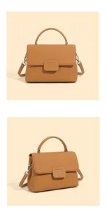Detail view of tan lychee grain leather shell bag with top handles and silver hardware