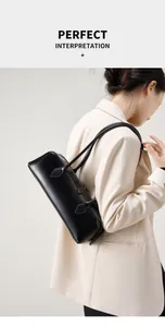 Dettaglio di una borsa baguette in pelle nera minimalista indossata a spalla da una modella