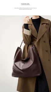 Primer plano de bolso tote de cuero marrón oscuro con costuras finas y acabado brillante