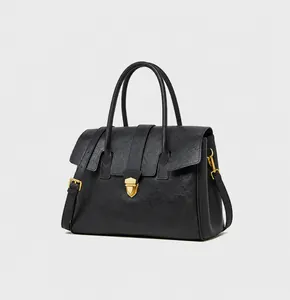Detailed close-up of high-quality black leather texture and gold metal buckle on tote bag