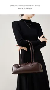 Dettaglio macro della borsa baguette in vera pelle marrone scuro con cerniera in metallo