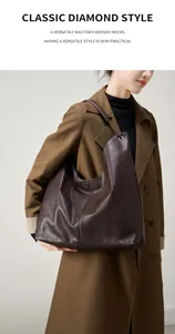 Modelo luciendo un gran bolso tote de cuero marrón oscuro tipo medialuna para estilo minimalista