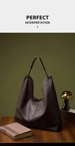 Detalle del bolso hobo de piel marrón oscuro con forro de rayas y herrajes metálicos