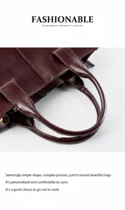 Dettaglio dei manici in pelle rinforzata e cerniera dorata della borsa tote rossa