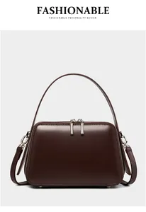 Detailed view of dark brown leather handbag with silver hardware and dual zippers