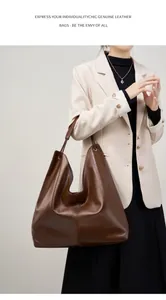 Detalle del bolso tote de cuero genuino marrón oscuro con textura suave en una modelo