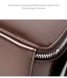 Macro shot of dark brown leather handbag featuring precision stitching and metal zipper