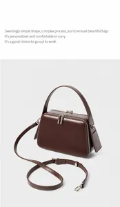 Detail view of smooth brown leather finish and polished metal hardware on women square handbag