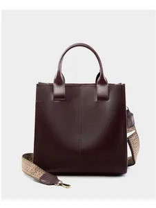 Dettaglio borsa tote in pelle bordeaux con tracolla in tessuto a motivi geometrici