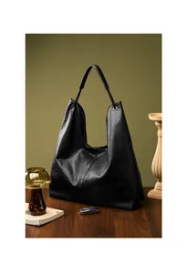 Bolso hobo grande de cuero negro sobre mesa de madera con llave de coche para referencia