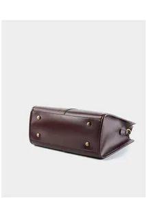 Dettaglio della base della borsa in pelle con quattro piedini in metallo dorato vintage