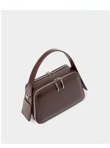 Top view of dark brown leather handbag with double zipper and silver metal hardware