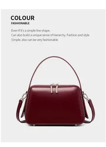 Detail of wine red leather handbag with smooth finish and gold metal hardware
