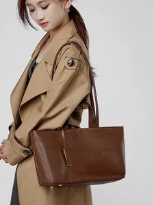 Borsa tote classica in pelle marrone scuro con grande capienza indossata da modella