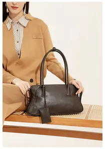 Detalle del bolso tote vintage de cuero marrón oscuro con asas elegantes y acabado texturizado