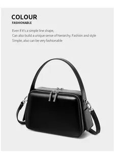 Close-up of black leather handbag featuring dual silver zippers and premium metal hardware