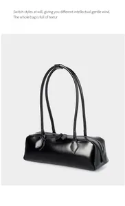 Dettaglio della borsa baguette in pelle nera con doppia cerniera e trama fine