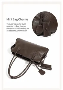 Detalle del bolso tote de cuero granulado marrón con mini estuche de cuero a juego