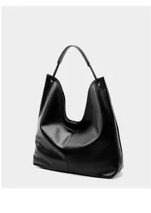 Detalle de bolso tote de cuero negro minimalista con ojales plateados y costuras