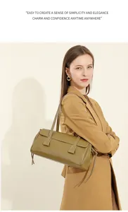 Detail of green leather baguette bag with tassel accents and slim shoulder strap