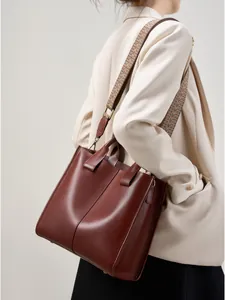 Borsa tote in pelle marrone rossiccio con tracolla fantasia indossata da modella