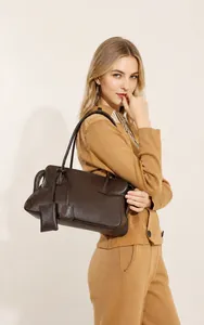 Detalle de bolso tote de cuero granulado marrón oscuro con doble asa fija