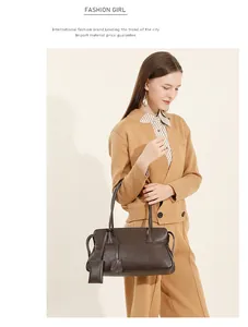 Detalle de bolso tote de cuero marrón oscuro llevado por una modelo con ropa chic