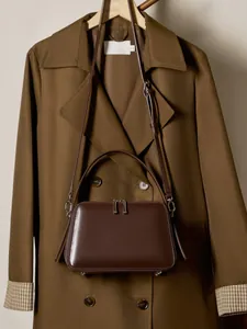 Classic dark brown leather trapezoid handbag with silver hardware and shoulder strap