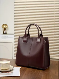 Borsa tote minimalista in pelle bordeaux con manici robusti e silhouette vintage a secchiello
