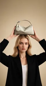 Elegante borsa Boston in pelle beige indossata da una modella in abito nero alla moda