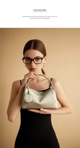 Dettaglio della borsa a mano in pelle beige con grana litchi e pendente tondo