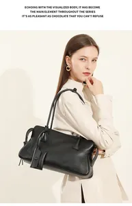 Detalle del bolso tote de cuero negro mate con grano fino y etiqueta cuadrada de cuero