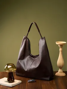 Bolso hobo grande de cuero marrón oscuro con ojales plateados y forro de rayas
