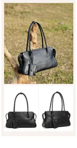 Detalle de bolso tote de cuero negro con asas largas y un mini monedero colgante