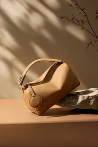 Dettaglio della pelle martellata e cerniera argentata su una borsa Boston cammello