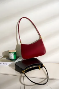 Minimalist leather baguette bags in burgundy and black with elegant light and shadow