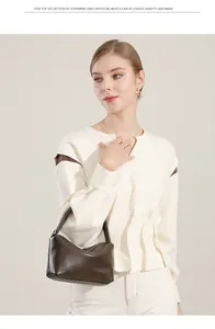 Dettaglio della borsa a mano in pelle marrone scuro abbinata a un outfit minimalista