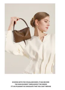 Vista dettagliata di una borsa a mano vintage in pelle marrone tenuta da una modella casual