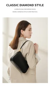 Side view of black leather half-moon shoulder bag with elegant gold buckle on strap