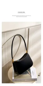 Detailed macro of black leather underarm bag with gold hardware and curved bottom