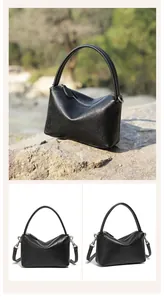 Primo piano dettagliato di una borsa minimalista in pelle nera con motivo litchi e zip argento