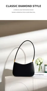Detail of minimalist black leather underarm bag with elegant gold hardware and curved handle