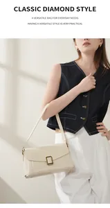 Detail of minimalist cream leather shoulder bag with vintage gold square metal buckle
