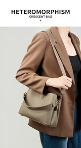 Modella che indossa una borsa a mezzaluna in pelle tortora con tracolla larga in tessuto