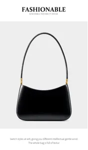 Close-up of sleek black leather shoulder bag with polished gold cylindrical hardware