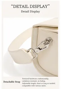 Detail of detachable shoulder strap with silver metal hooks on a cream leather bag